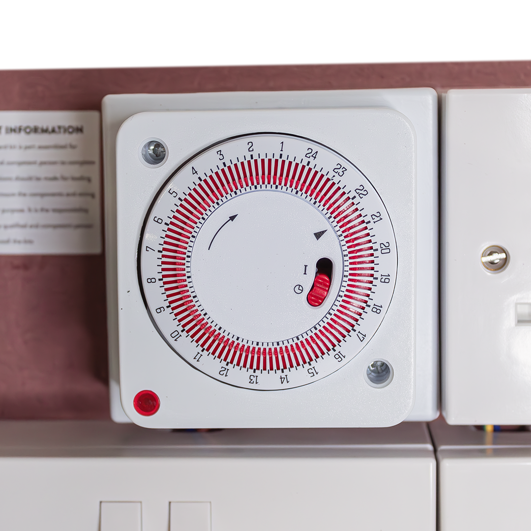 Analog timer dial on white contactor module with red and black indicator