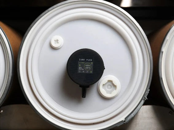 White circular base with black sensor puck label and attached power connector